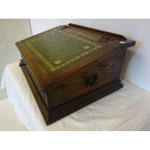 323 - Slope front oak stationery box with leather inset.