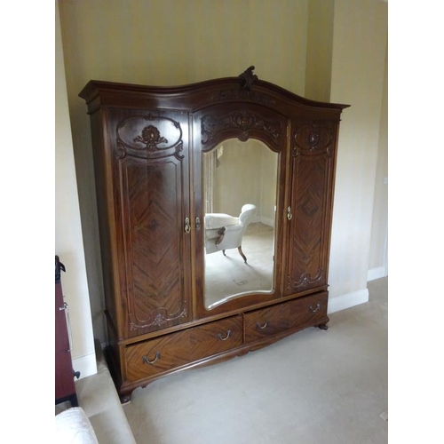 339 - Large three door mahogany wardrobe with well fitted interior, the centre with mirror door by Warring... 