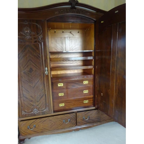 339 - Large three door mahogany wardrobe with well fitted interior, the centre with mirror door by Warring... 