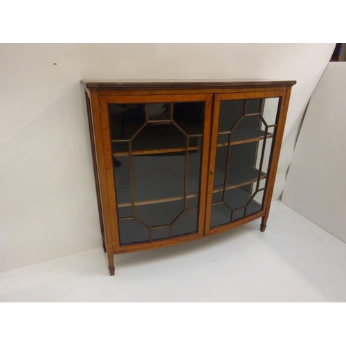 369 - A good antique bow shaped satinwood cabinet having section glass doors and raised on tapered legs. W... 