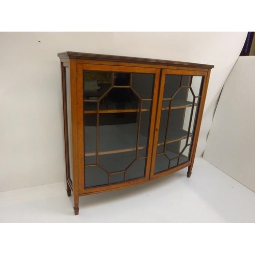 369 - A good antique bow shaped satinwood cabinet having section glass doors and raised on tapered legs. W... 