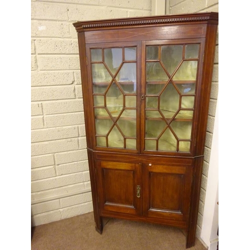 79 - Antique inlaid mahogany corner cabinet, the upper part with sectioned glass doors, the base with pan... 