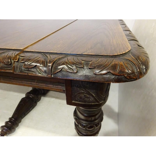 106 - Victorian oak dining table having two spare leaves and raised on five legs with harp decoration.