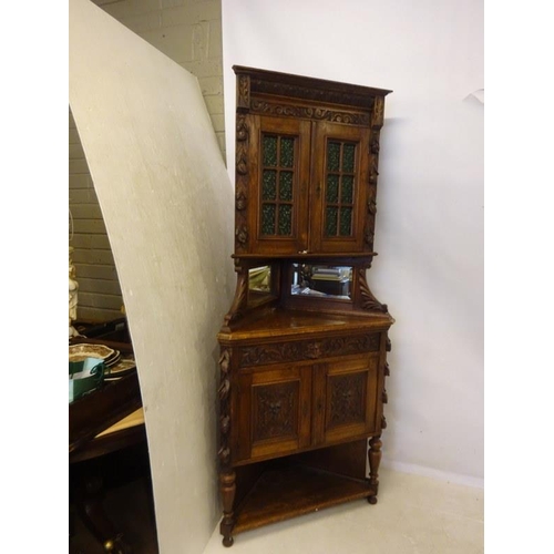 194 - Victorian carved oak corner cabinet, the upper section with green glass door panels. H. 212cm, W. 90... 