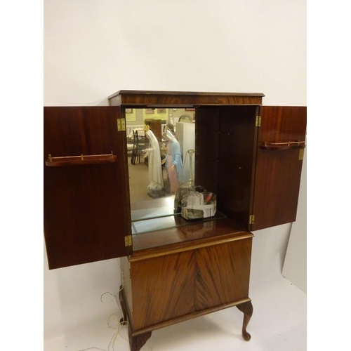 308 - Walnut four door drinks cabinet raised on Queen Anne style legs. H. 148cm, W. 72cm, D. 40cm approx.