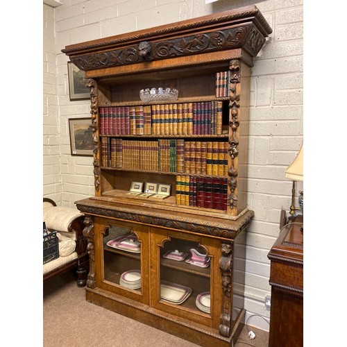 291 - A large 19th century carved oak bookcase, the upper section  having decorative freize over three ope... 