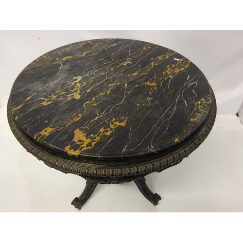 107 - A 19th century table having a circular marble top on an ebonized frame with centre column and carved... 