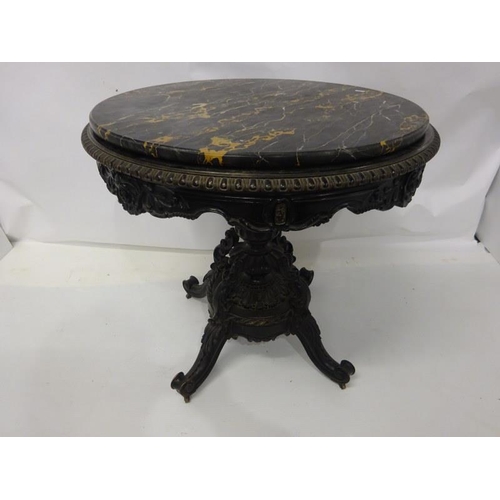 107 - A 19th century table having a circular marble top on an ebonized frame with centre column and carved... 