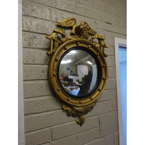 125 - Antique gilt framed convex mirror surrounded with an eagle.