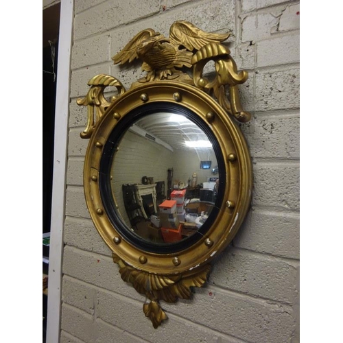 125 - Antique gilt framed convex mirror surrounded with an eagle.