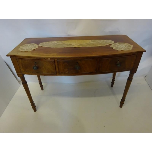 129 - A Cork Regency mahogany bow shaped side table fitted with 3 drawers and raised on turned legs. W. 12... 