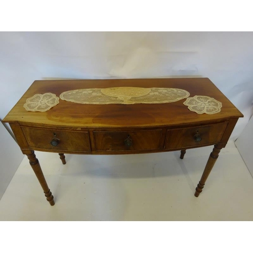 129 - A Cork Regency mahogany bow shaped side table fitted with 3 drawers and raised on turned legs. W. 12... 