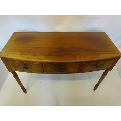 129 - A Cork Regency mahogany bow shaped side table fitted with 3 drawers and raised on turned legs. W. 12... 