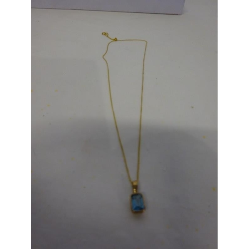 185 - 9ct yellow gold topaz pendant and chain.