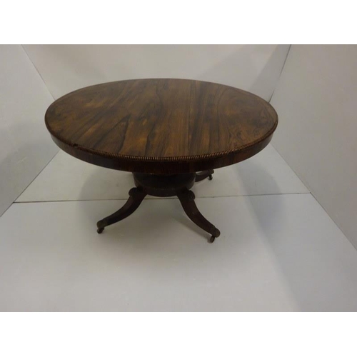 242 - A Regency rosewood circular dining table raised on turned column platform base and 4 splay legs with... 