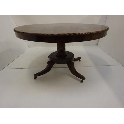 242 - A Regency rosewood circular dining table raised on turned column platform base and 4 splay legs with... 