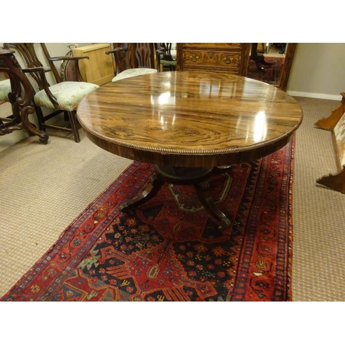 242 - A Regency rosewood circular dining table raised on turned column platform base and 4 splay legs with... 