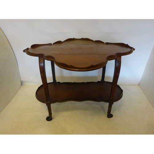 61 - Antique mahogany two tier trolley having brass handles shaped drop leaves and raised on wheels. W. 1... 