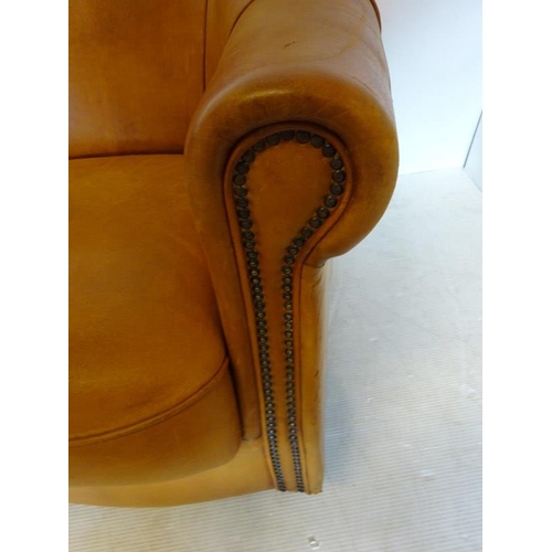 66 - Comfortable leather upholstered tub shaped easy chair with markers label on reverse.