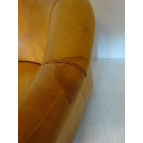 66 - Comfortable leather upholstered tub shaped easy chair with markers label on reverse.