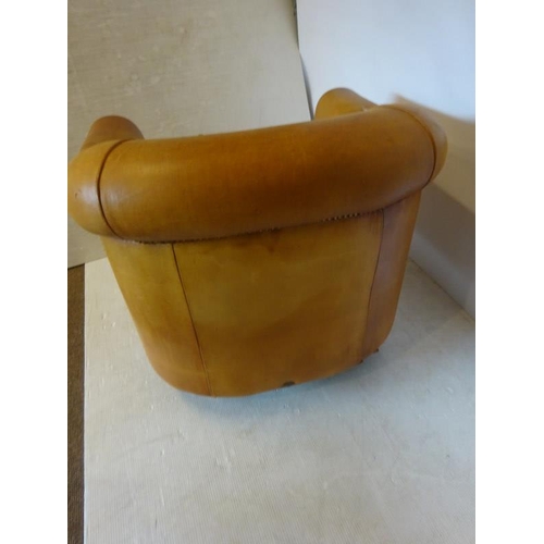 66 - Comfortable leather upholstered tub shaped easy chair with markers label on reverse.