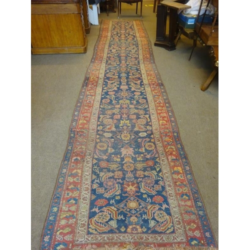 103 - A long old Persian runner rug. 485cm x 116cm.