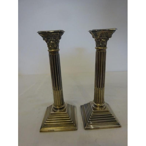 193 - A pair of silver corinthian column candlesticks on stepped bases, Birmingham 1921. H. 25cm.