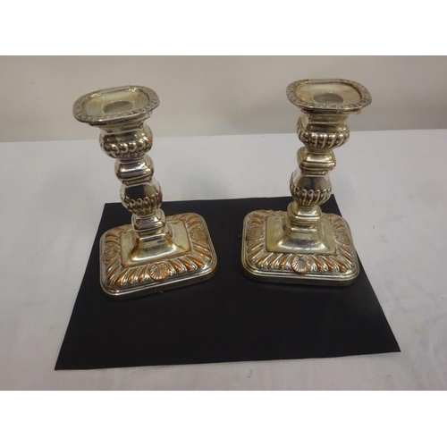 196 - A pair of antique Sheffield silver plated candlesticks on decorative rectangular shape bases.