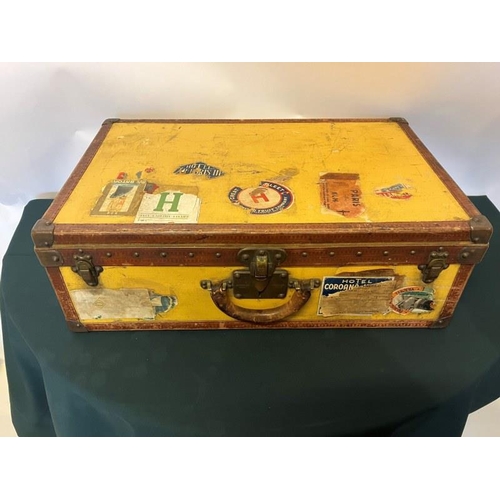 236 - Louis Vuitton suitcase, leather trimmed and studded and covered with travel stickers and monogrammed... 