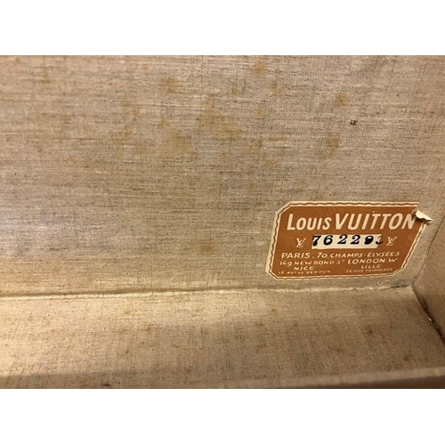 236 - Louis Vuitton suitcase, leather trimmed and studded and covered with travel stickers and monogrammed... 