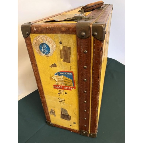 236 - Louis Vuitton suitcase, leather trimmed and studded and covered with travel stickers and monogrammed... 