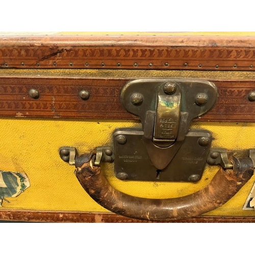 236 - Louis Vuitton suitcase, leather trimmed and studded and covered with travel stickers and monogrammed... 