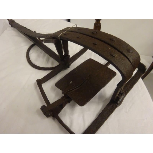 245 - A rare antique hand forged metal trap together with a book, The Steel Trap in North America. (2)