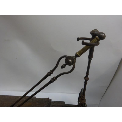 253 - A very good antique steel and brass fender complete with stands and irons. W. 112cm.