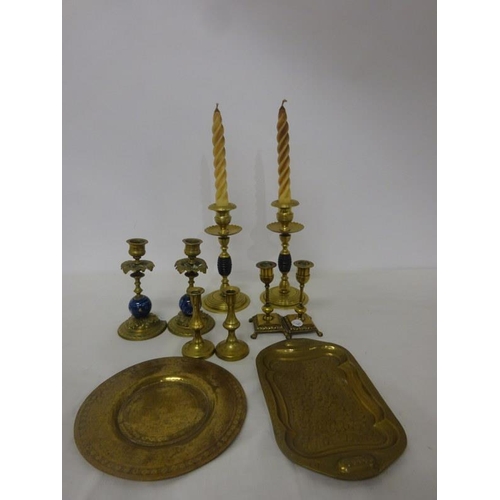 260 - Four pairs of old brass candlesticks and two small brass trays.