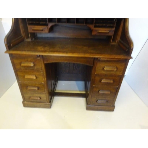 305 - Antique oak roll top writing desk fitted with drawers and pull out writing slides. Width 120cm.