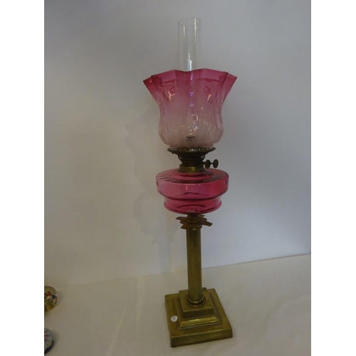 321 - A good antique brass column oil lamp with red bowl and shade in good condition.