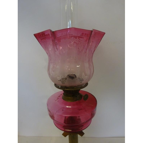 321 - A good antique brass column oil lamp with red bowl and shade in good condition.