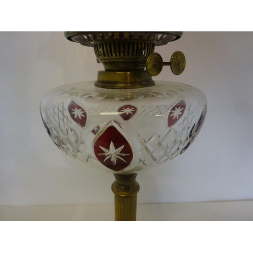 322 - Antique brass column oil lamp having clear glass bowl with red glass decoration and red glass shade ... 