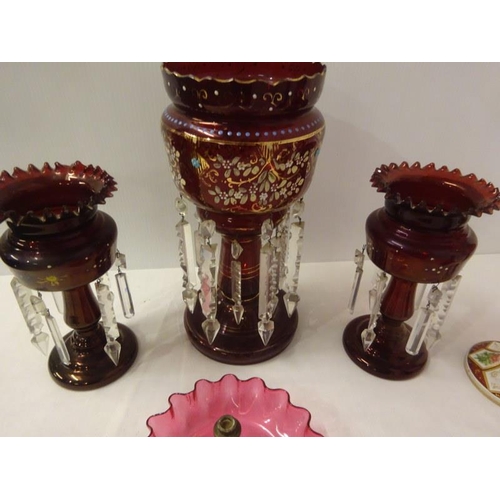 324 - A pair of red glass mantle piece lustres, one large mantle piece lustre, two red glass vases and a e... 