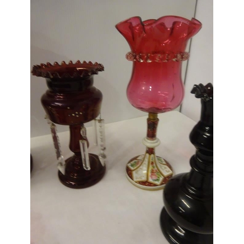 324 - A pair of red glass mantle piece lustres, one large mantle piece lustre, two red glass vases and a e... 