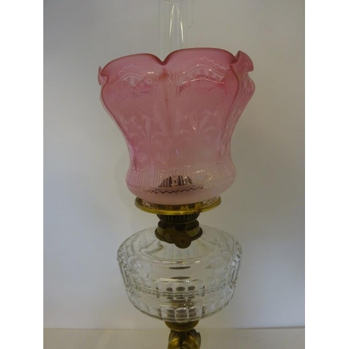 325 - Antique brass column oil lamp having clear glass bowl and red glass shade in fine condition.