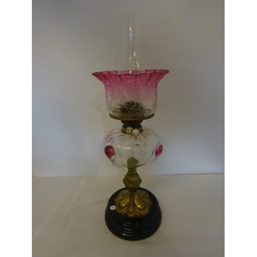 326 - Antique brass column oil lamp having clear glass bowl with tear drop decoration and red glass shade ... 