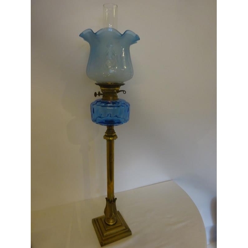 329 - Tall brass column oil lamp with blue glass bowl and shade (crack in bowl, see photo). H. 94cm.