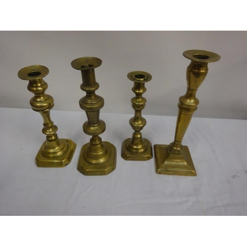 352 - Four old brass candlesticks.