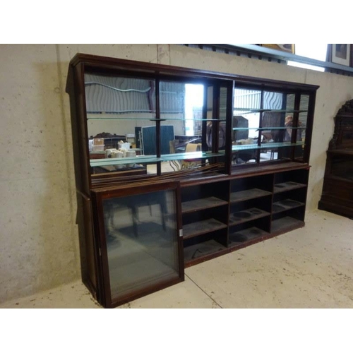 79 - A large Edwardian mahogany shop cabinet, the upper section fitted with glass shelves and sliding doo... 