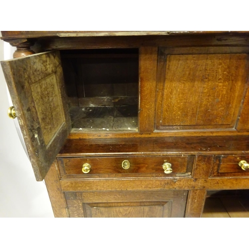 123 - A good 18th century oak court cupboard in three sections, the top section having plate rack with lat... 