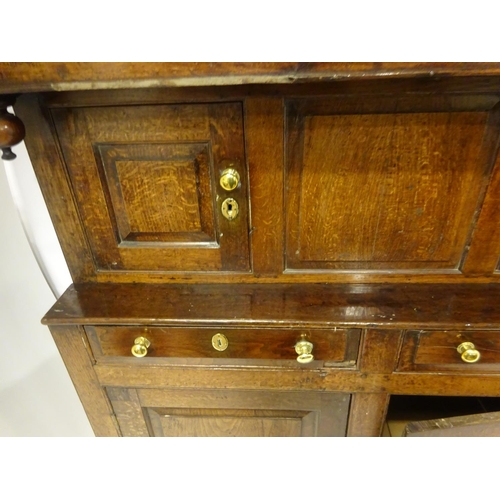 123 - A good 18th century oak court cupboard in three sections, the top section having plate rack with lat... 