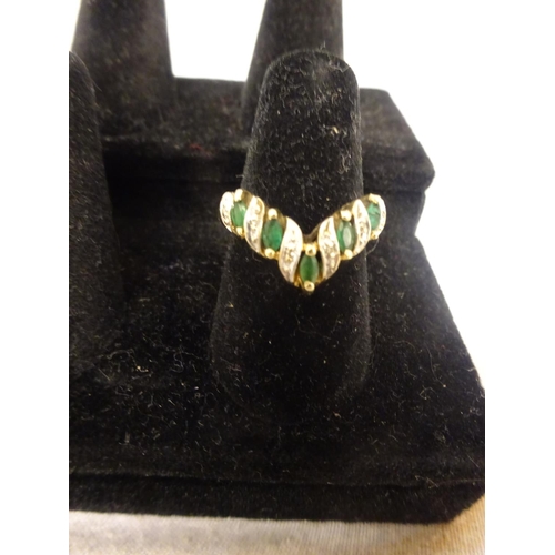 221 - A 10k emerald and diamond ring set with 5 marquise/shaped pale emeralds, edged  by small brilliant c... 