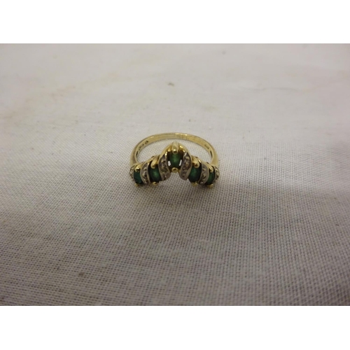 221 - A 10k emerald and diamond ring set with 5 marquise/shaped pale emeralds, edged  by small brilliant c... 